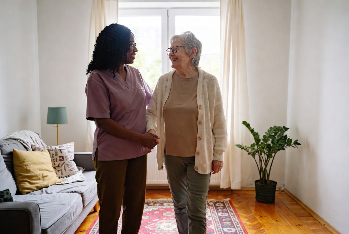 Caregiver gently helping an elderly woman walk